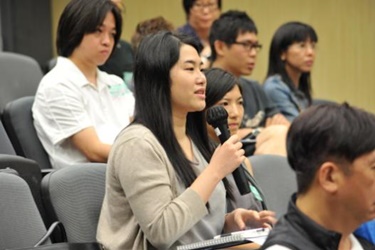 A participant poses a question at a seminar