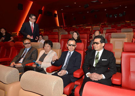 Mr Gregory So (front row, first right) is briefed by the Managing Director of Hopewell Holdings Limited, Mr Thomas Wu (front row, second right), on the advanced projection system and watches the screening of a 3D movie trailer. 
