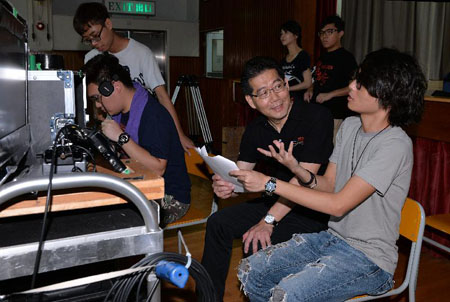 The Secretary for Commerce and Economic Development, Mr Gregory So, today (August 16) observed the shooting of the film 'Weeds on Fire'. Picture shows Mr So (left) talking with the director, Mr Chan Chi-fat (right), to learn more about how the film project has benefited from the First Feature Film Initiative and the challenges encountered during the filming process.